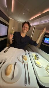 a man sitting at a table with a glass of wine