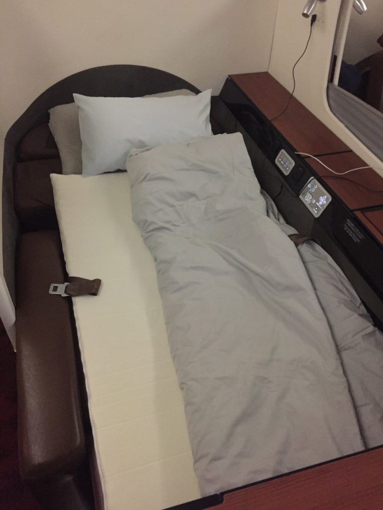 a bed with a pillow and a seat belt