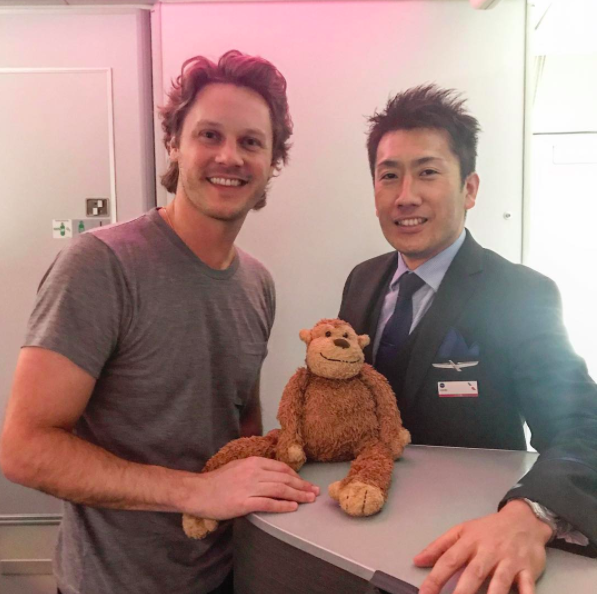 two men standing next to a stuffed animal