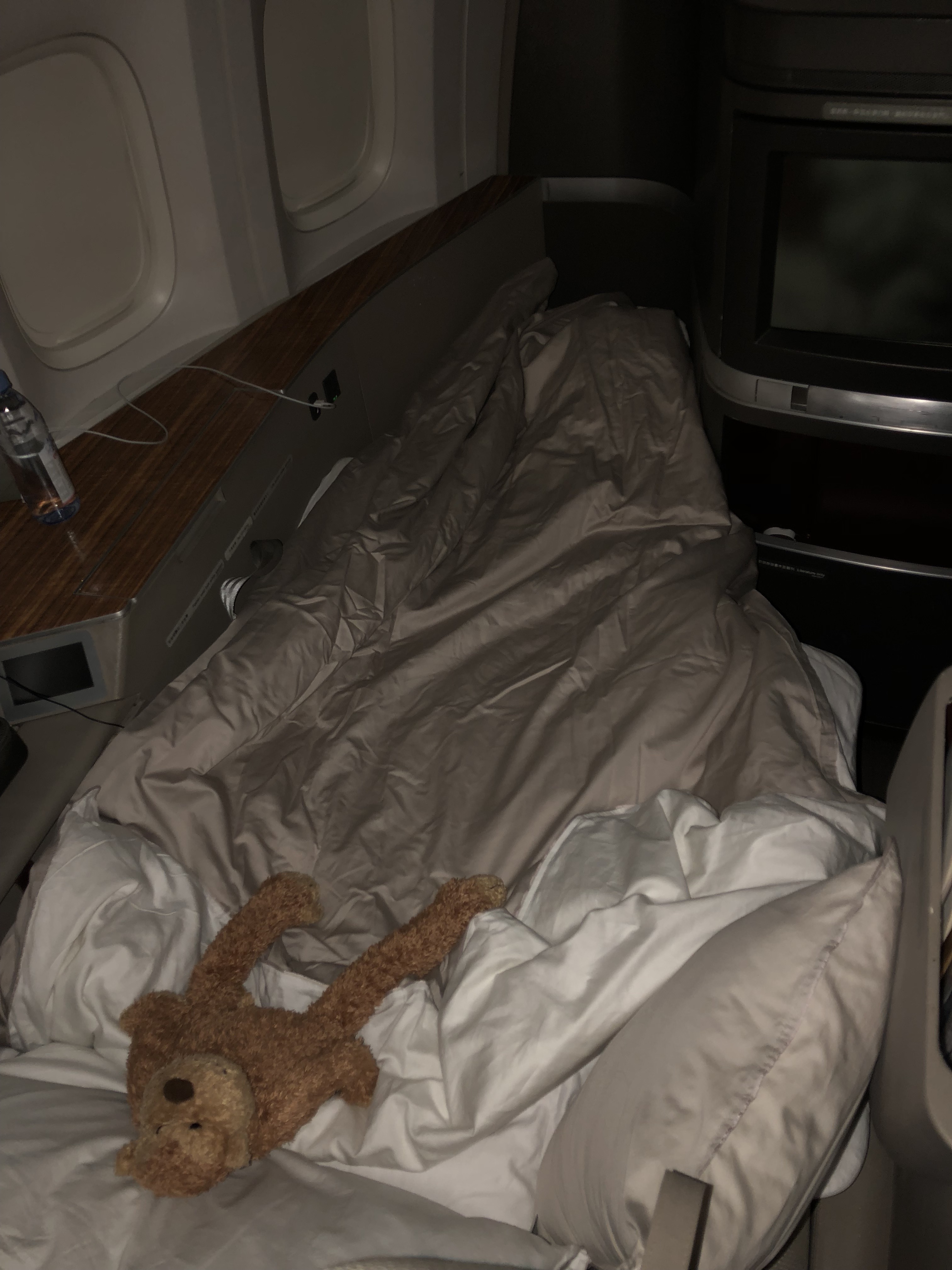 a bed with a teddy bear on it