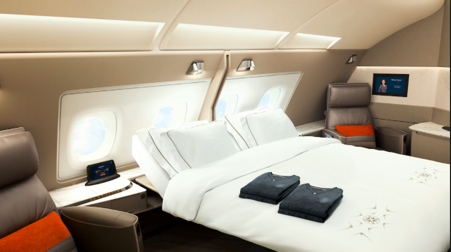 a bed with white sheets and pillows in an airplane