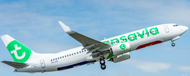 a white airplane with green and blue text