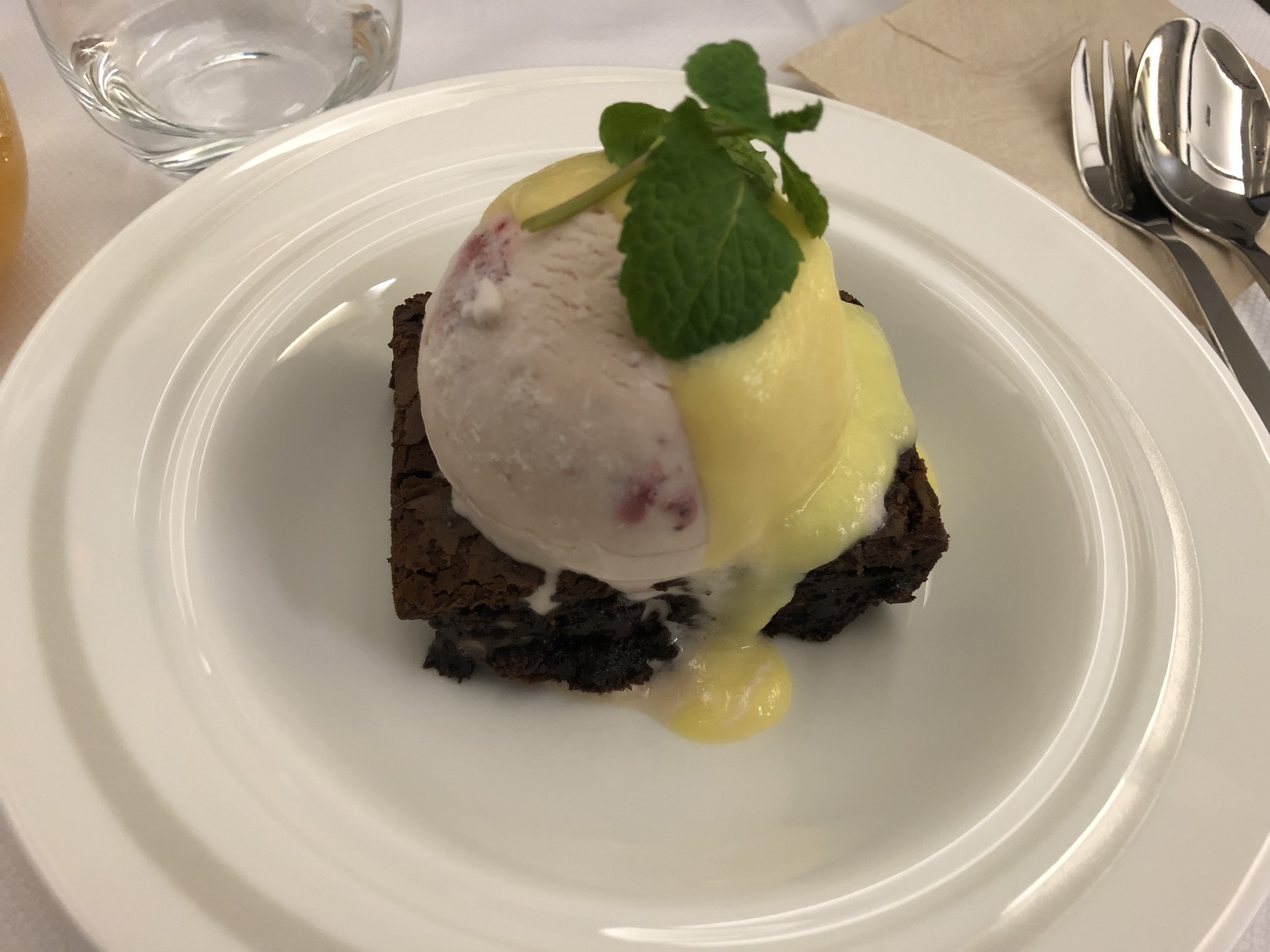 a brownie with ice cream and mint on a plate