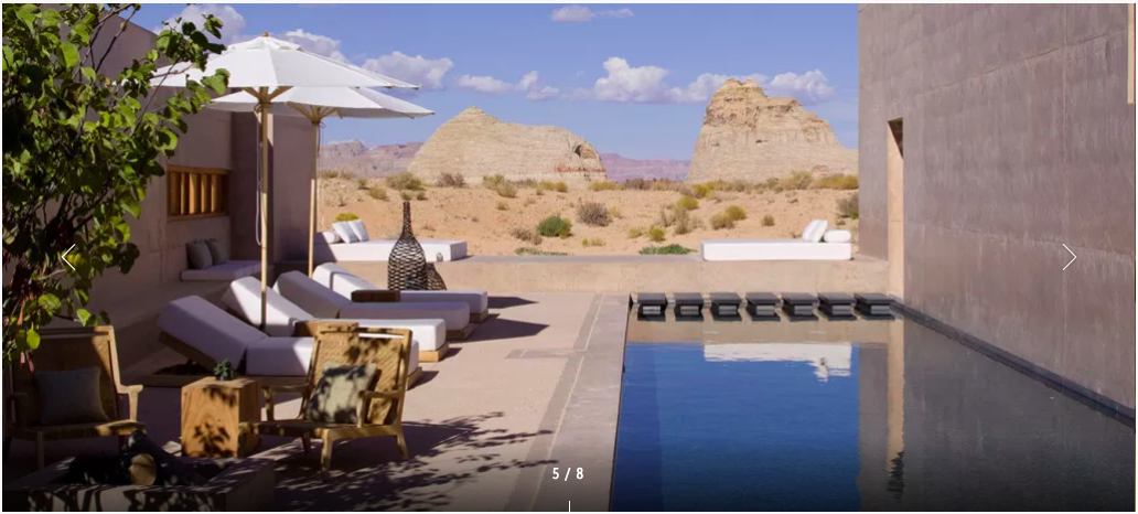 a pool with chairs and a chair in the middle of a desert