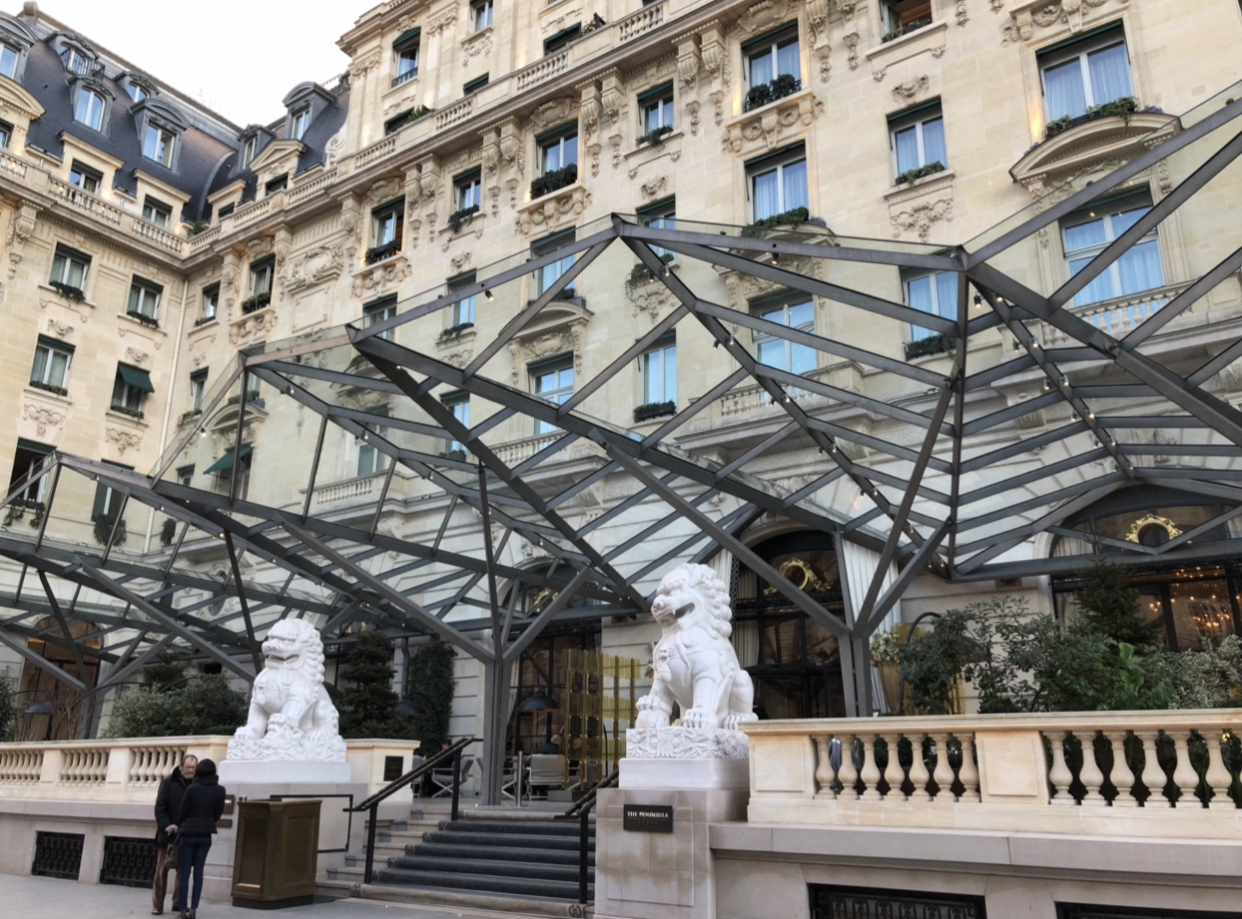 a building with a glass roof and statues of lions