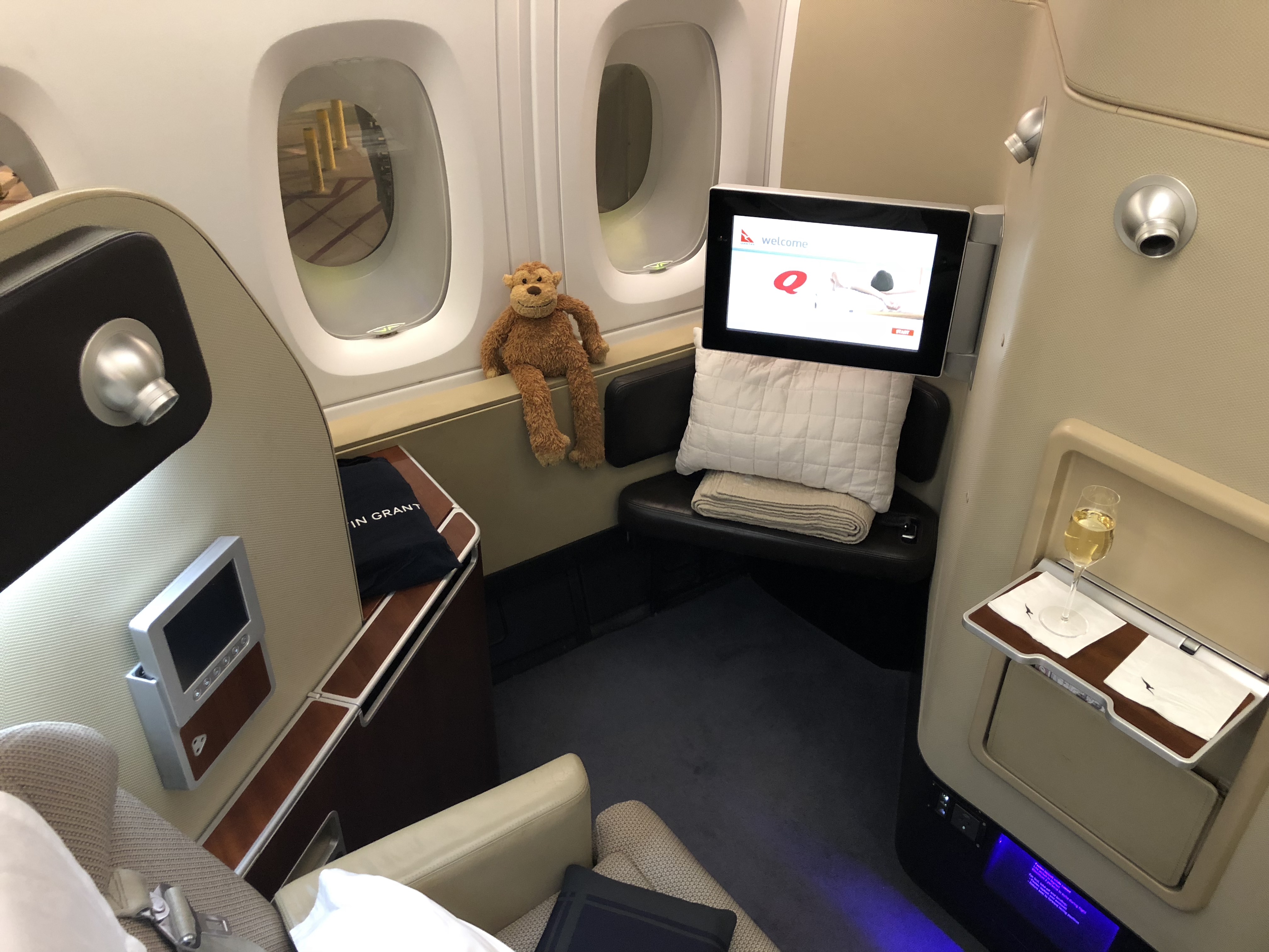 a teddy bear sitting on a window seat in an airplane