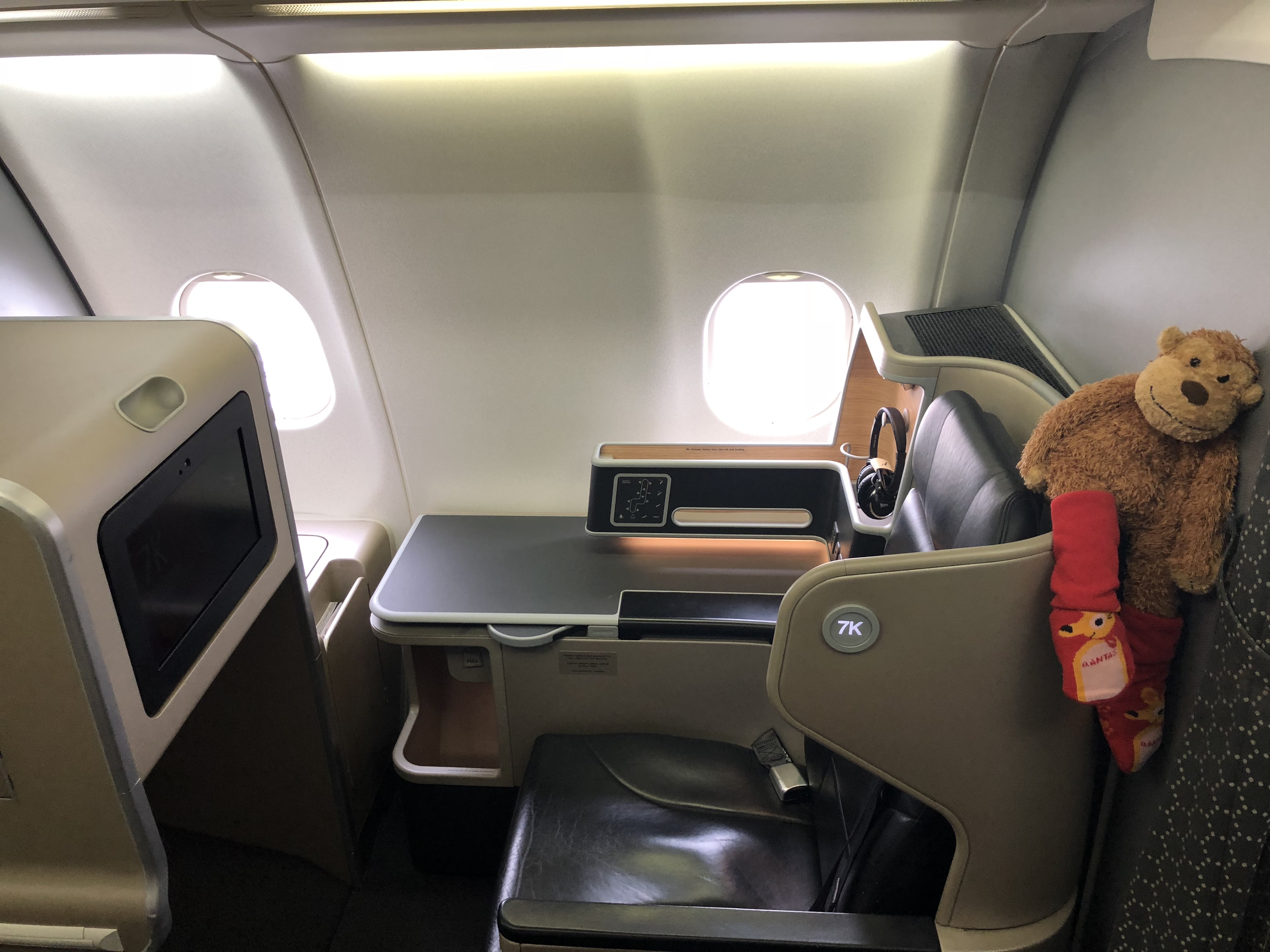 a teddy bear in a chair in an airplane
