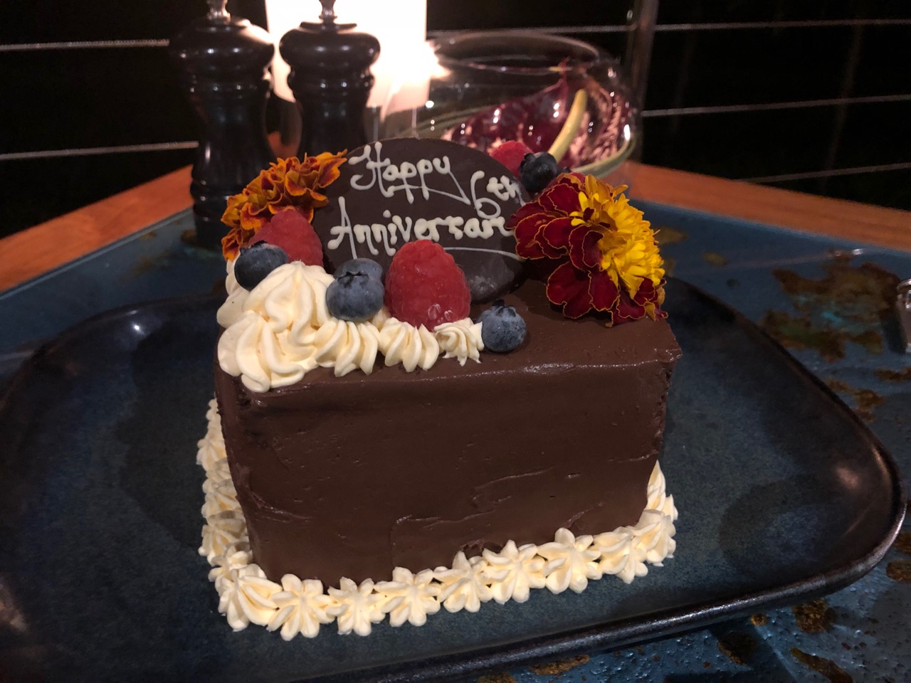 a chocolate cake with flowers and a sign on it