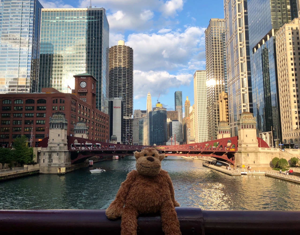 a stuffed animal on a railing overlooking a river