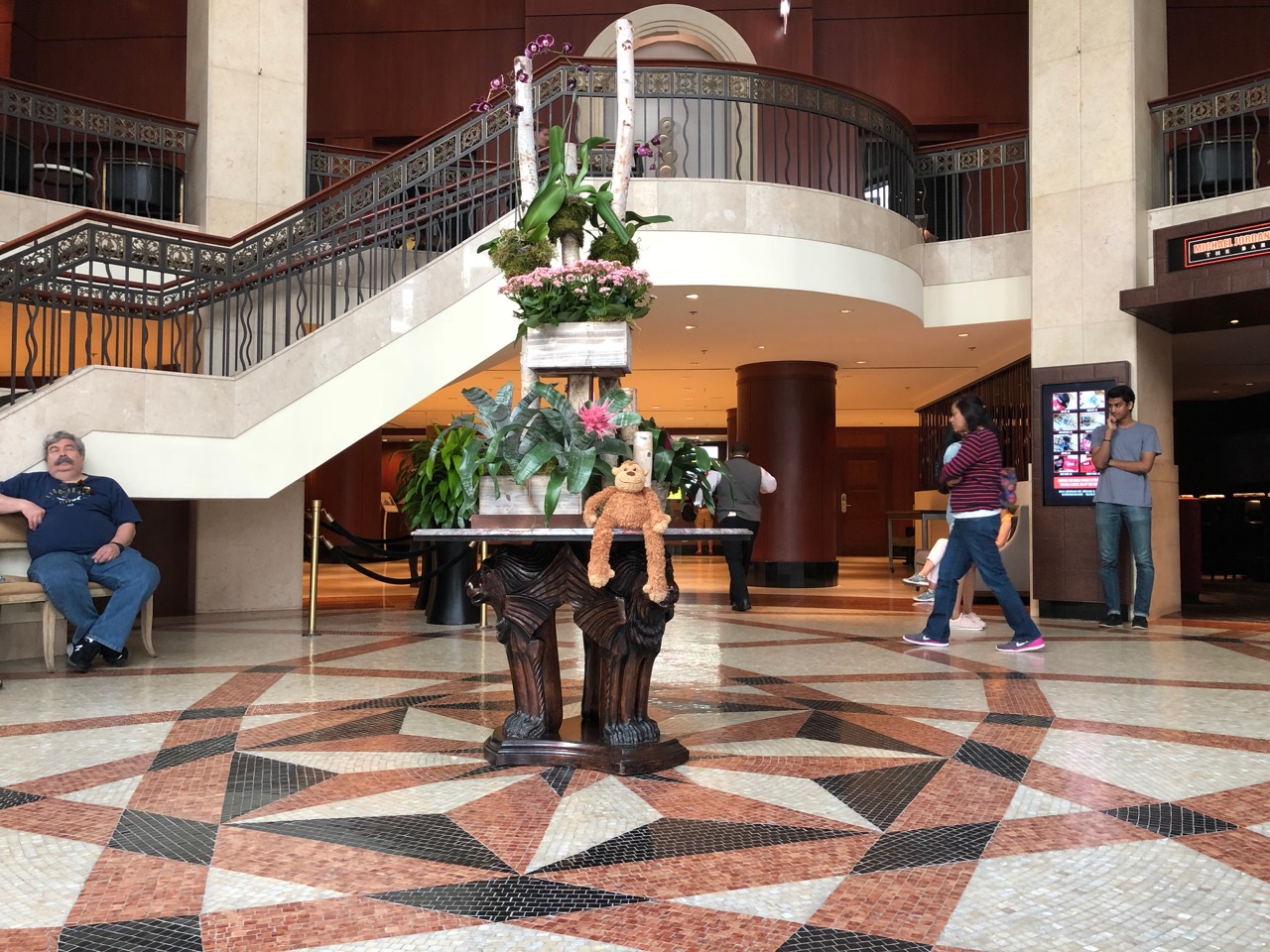 a large marble floor with a staircase and a statue of a teddy bear