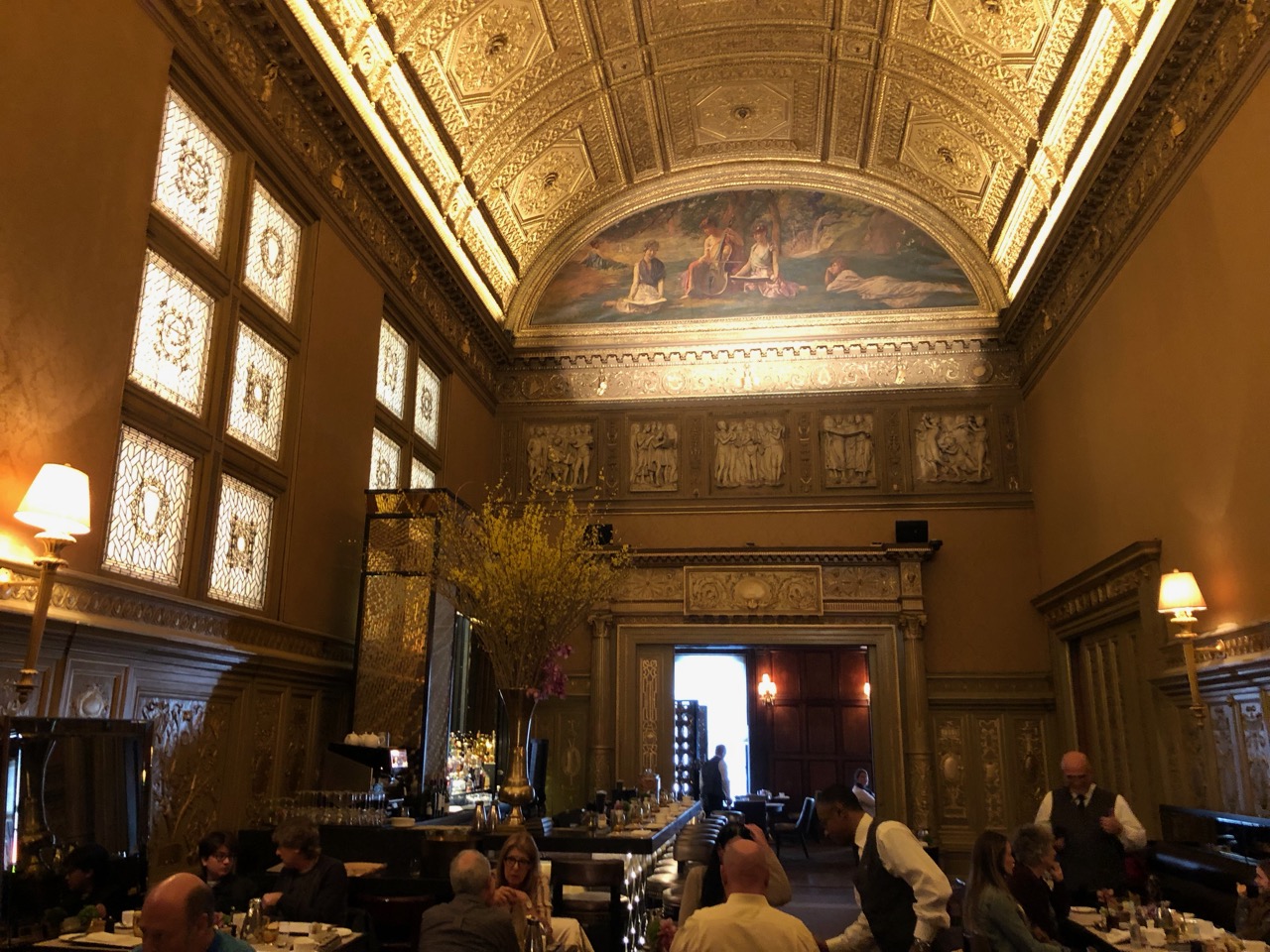 a room with a large ceiling and a group of people sitting at tables
