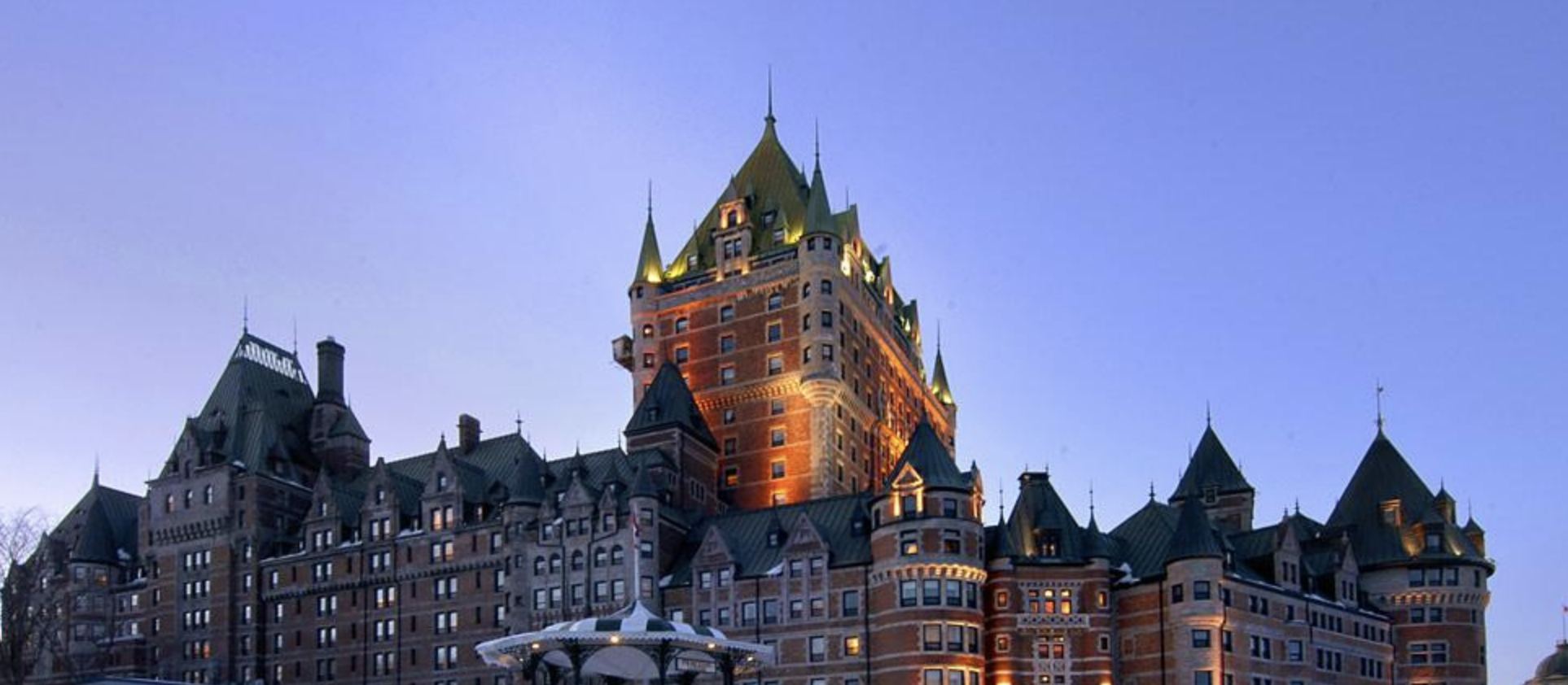 a large building with many windows with Château Frontenac in the background