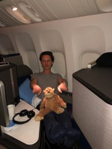 a man sitting in an airplane with a stuffed animal