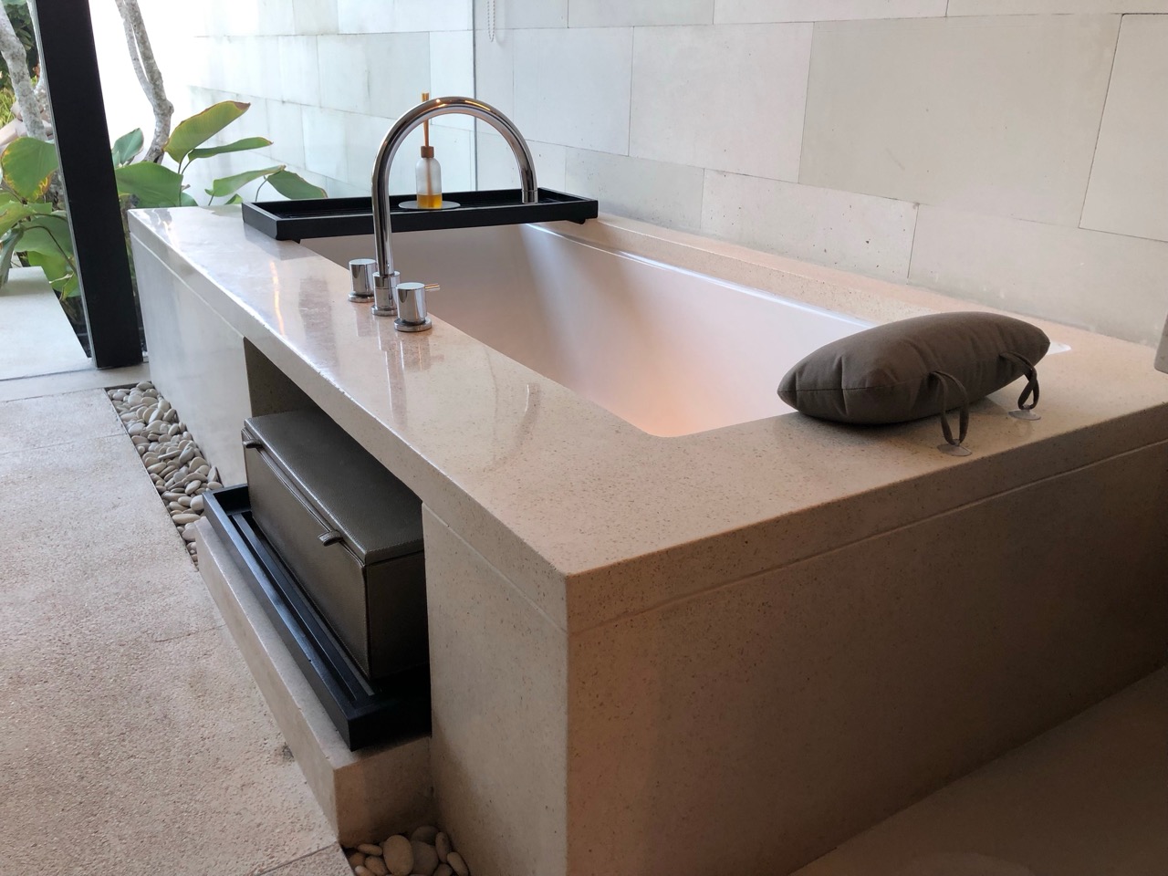 a bathtub with a sink and a pillow