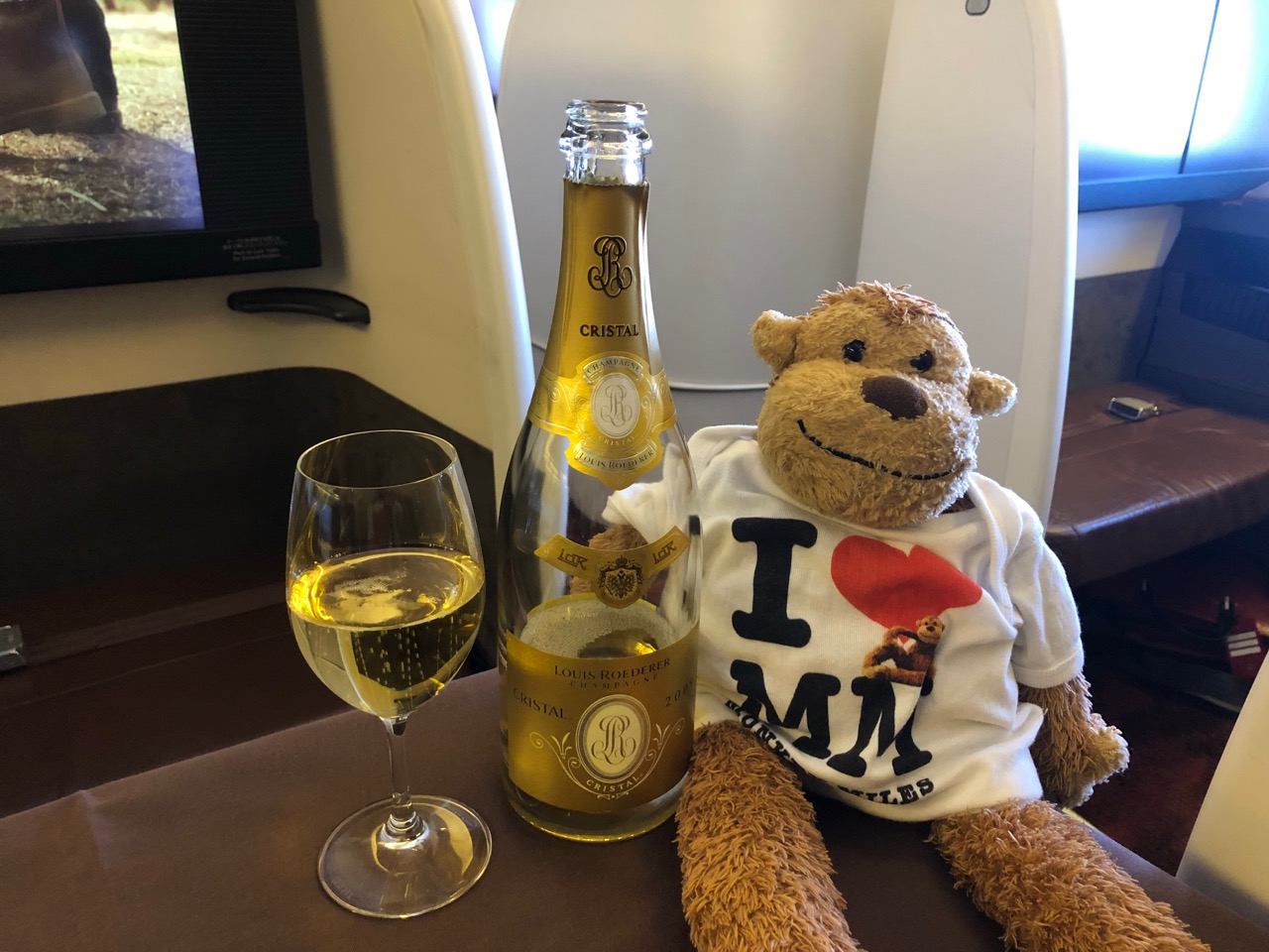 a stuffed animal next to a glass of wine