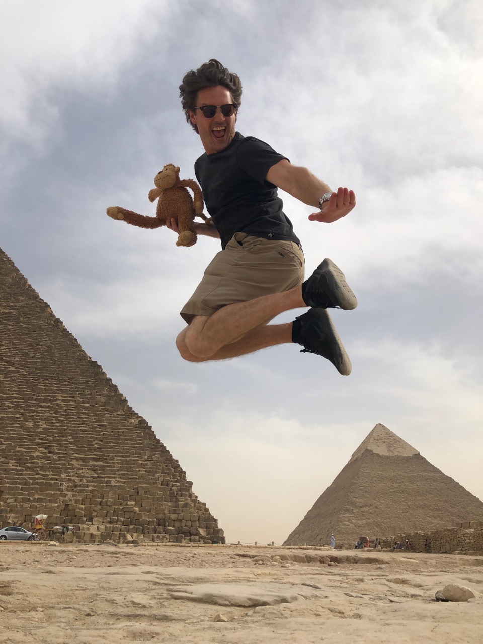 a man jumping in the air with a stuffed animal and a pyramid