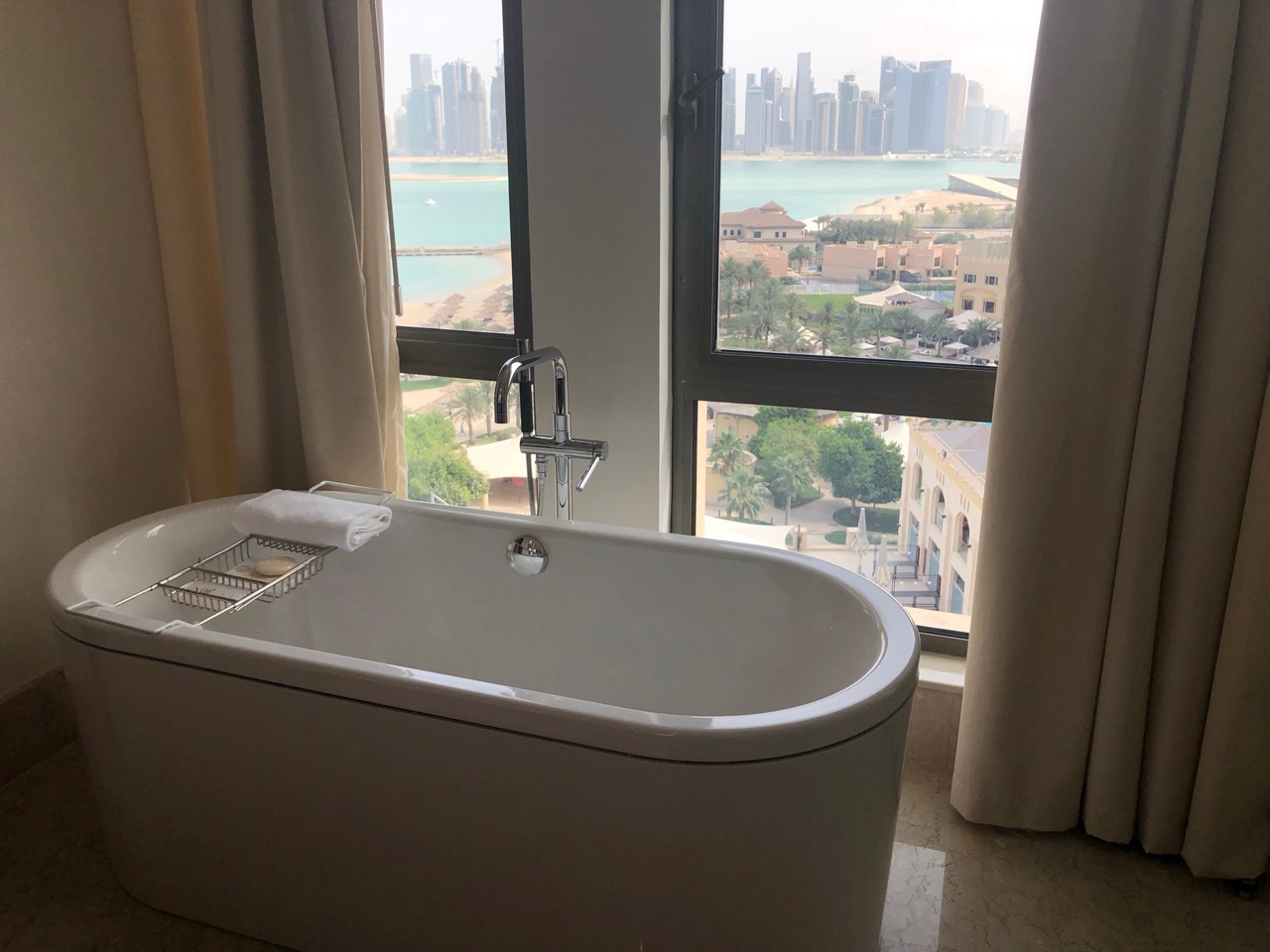 a bathtub in a bathroom with a view of a city and water