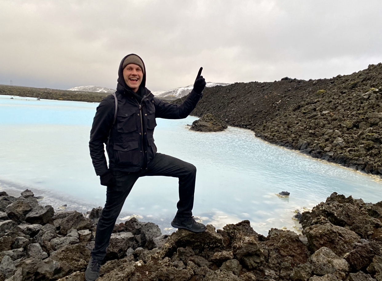 a man standing on rocks and pointing up