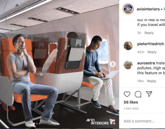 a man sitting in an airplane with a laptop