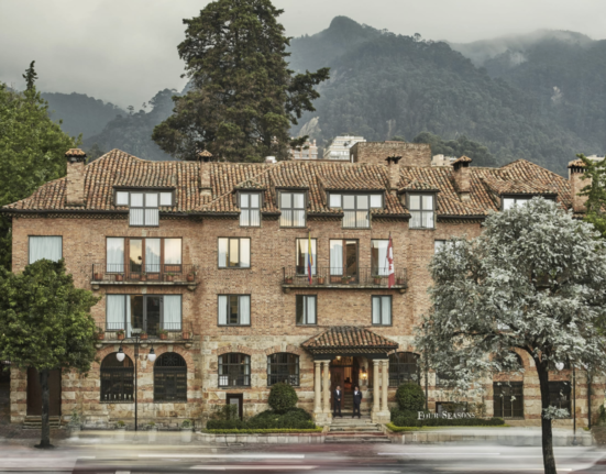 a building with trees and mountains in the background