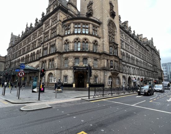 a large stone building with a large tower and a street