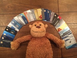 a stuffed animal lying on a wood floor with many credit cards around it