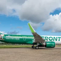 a green and white airplane on a runway