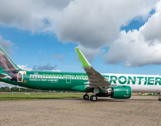 a green and white airplane on a runway