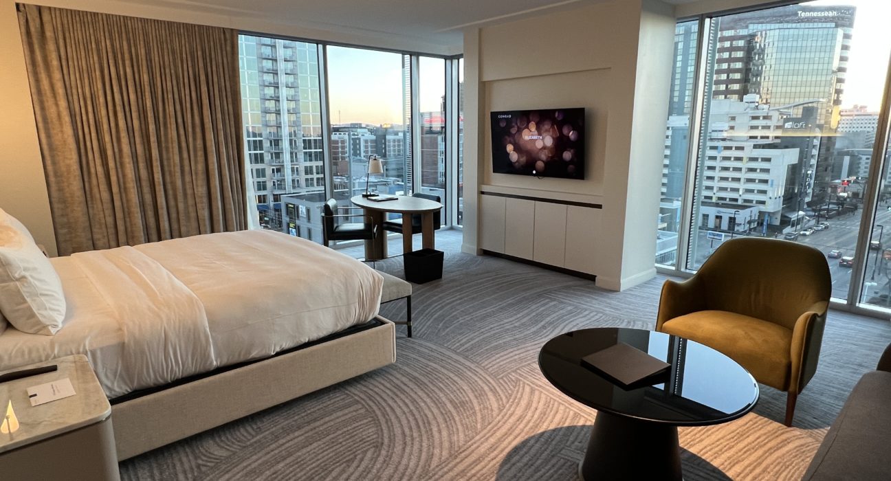 a room with a bed and a table and a television