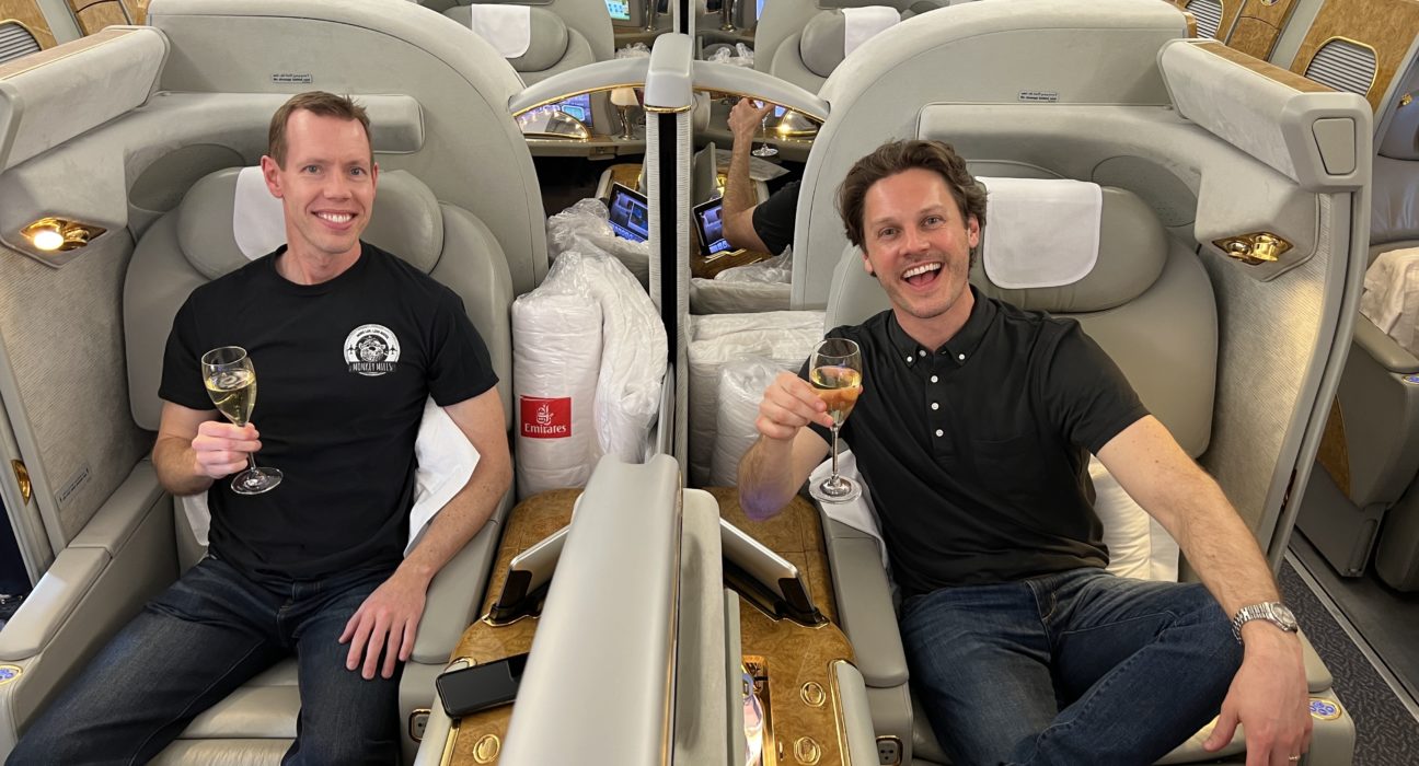 two men sitting in chairs on an airplane