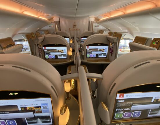 the inside of an airplane with seats and screens