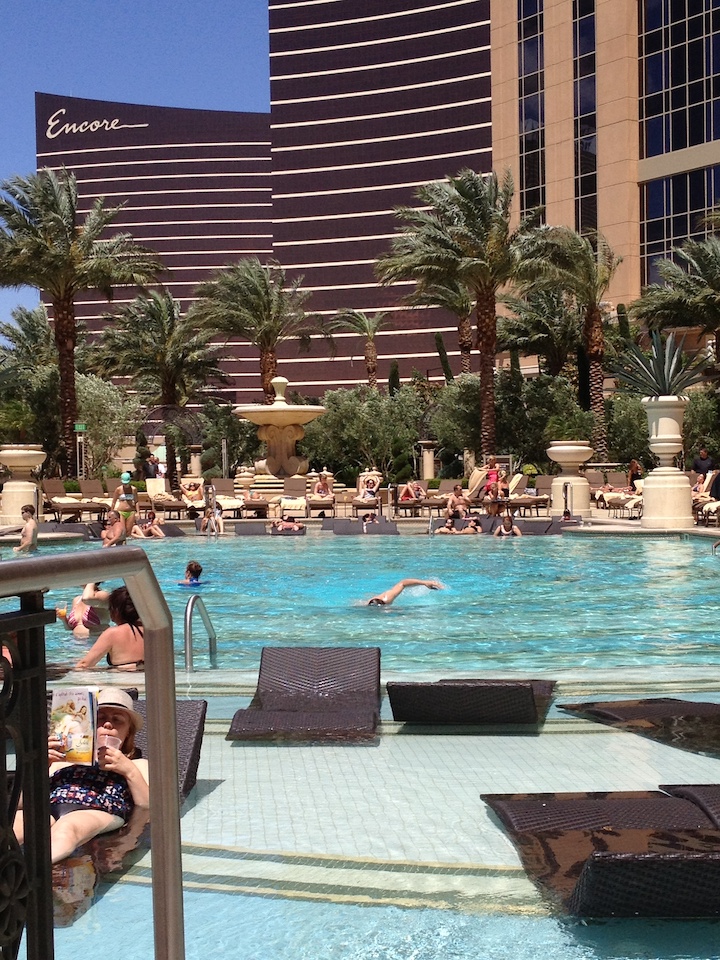 a pool with palm trees and people in the background