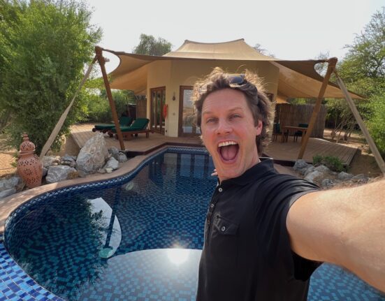 a man taking a selfie by a pool