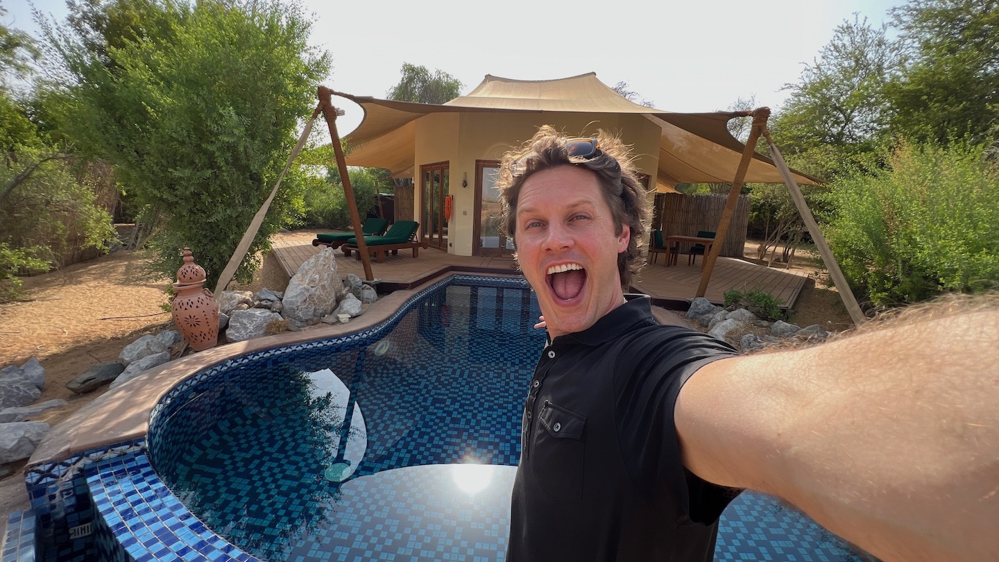 a man taking a selfie by a pool