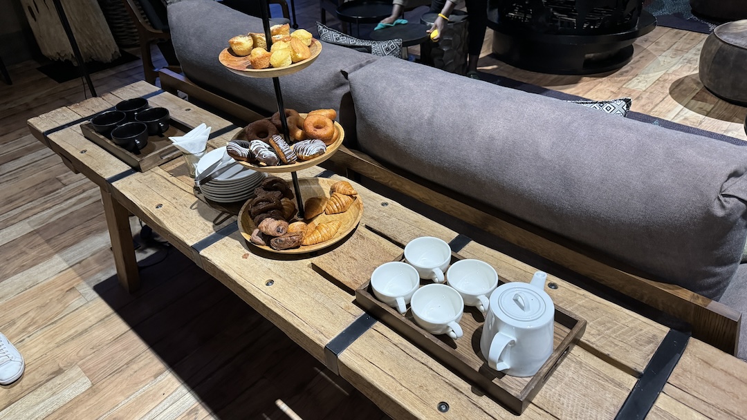 a tray of pastries and coffee cups on a table