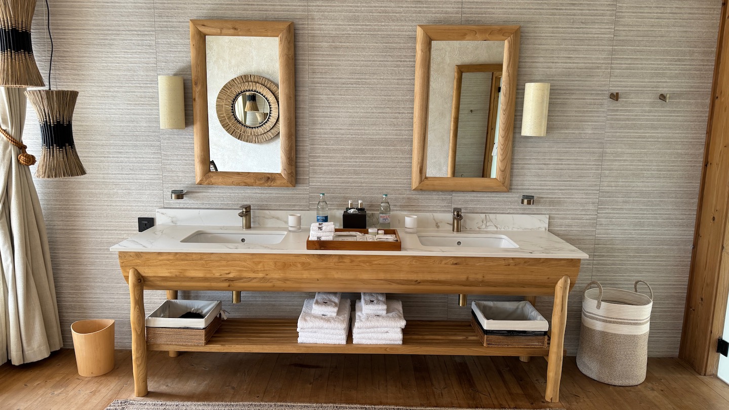 a bathroom with a wood vanity and mirrors