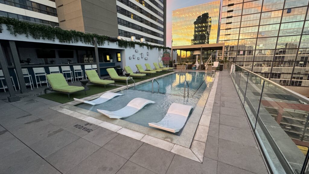 a pool with lounge chairs and a building in the background