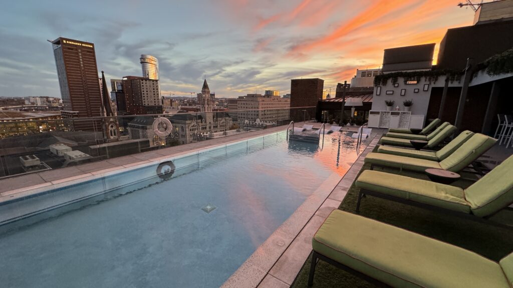 a pool with chairs and a city skyline