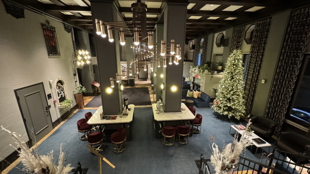 a room with a christmas tree and a chandelier