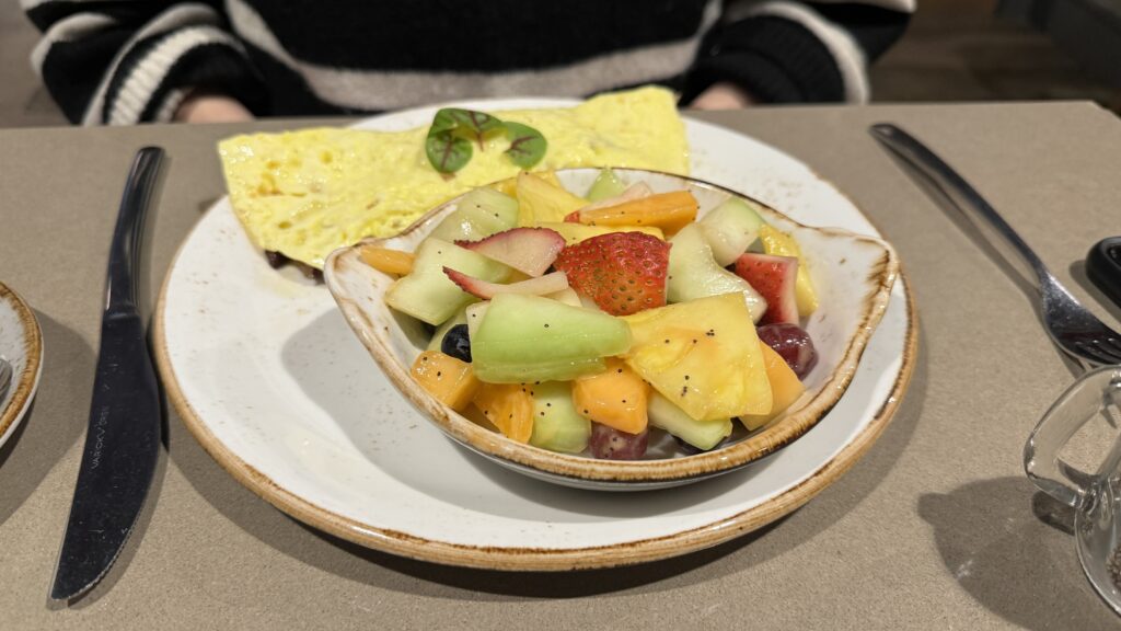 a plate of fruit and omelette