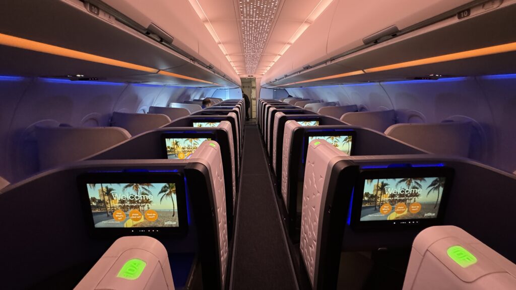 a row of seats with monitors on the side
