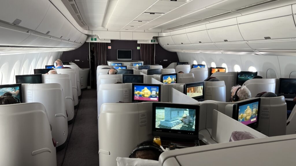 a group of people sitting in an airplane with computers