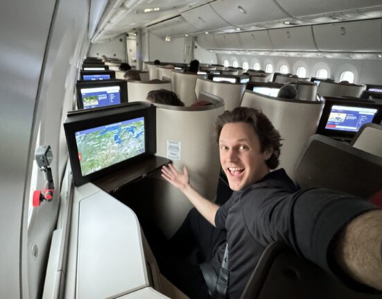 a man sitting in an airplane with a computer