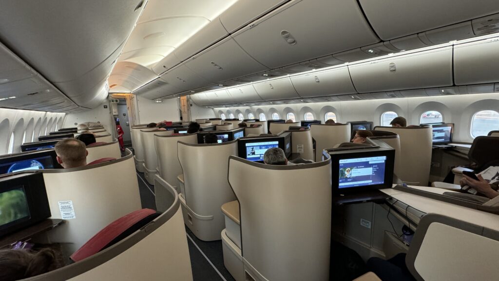 a group of people sitting in a row of seats on an airplane