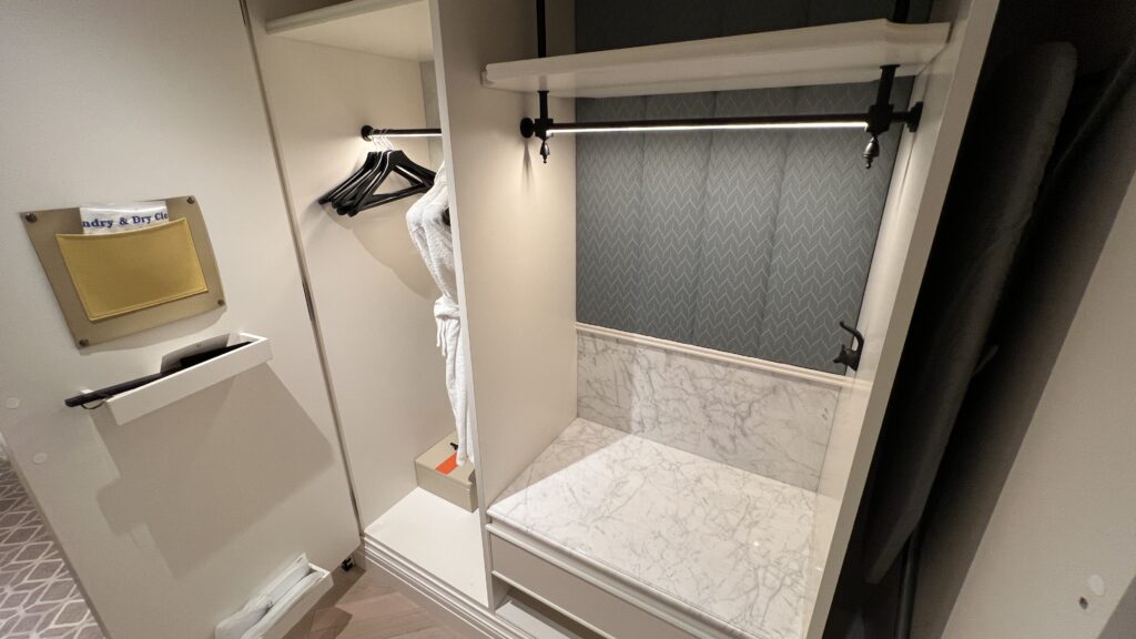 a white closet with a white towel on a rack