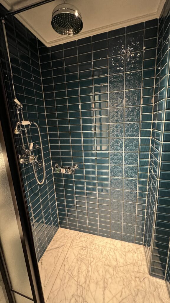 a shower with blue tiles