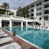 a pool with chairs and a building in the background