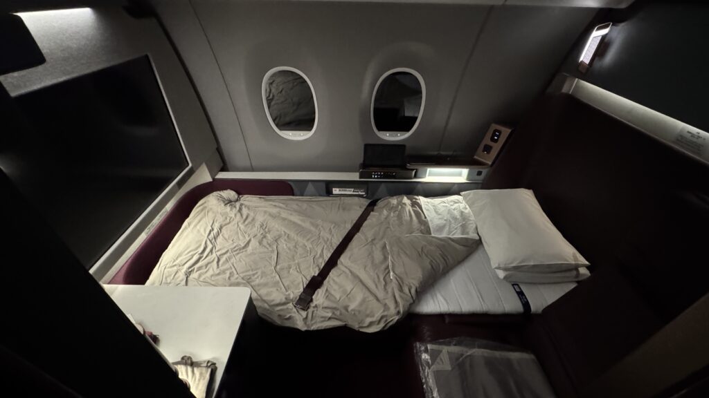 a bed with a seat belt and pillows