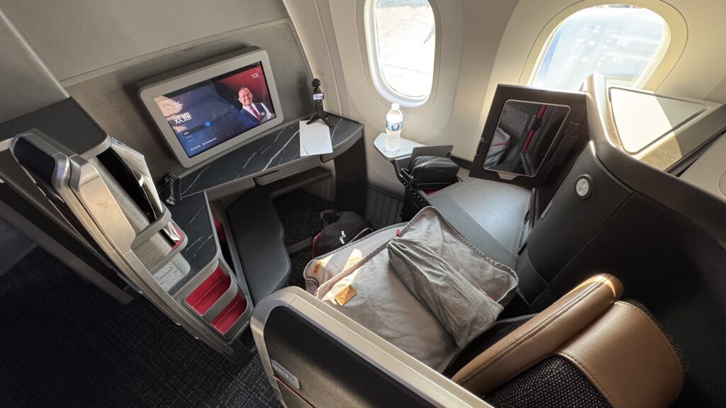 a seat with a television and a window in the back